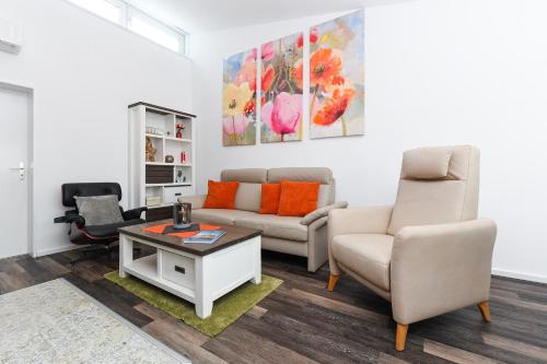 ein Wohnzimmer mit einem Sofa und 2 Stühlen in der Unterkunft Ferienhaus Krosse Krabbe in Bensersiel
