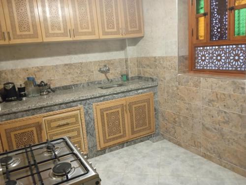 a kitchen with a stove and a counter top at Maison Moussaoui in Meknès
