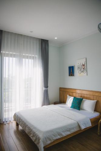 a bedroom with a large bed and a window at SEN VILLA Boutique in Bao Loc