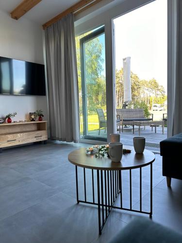 a living room with a table and a large window at Bałtyckie Zacisze Kopalino in Kopalino