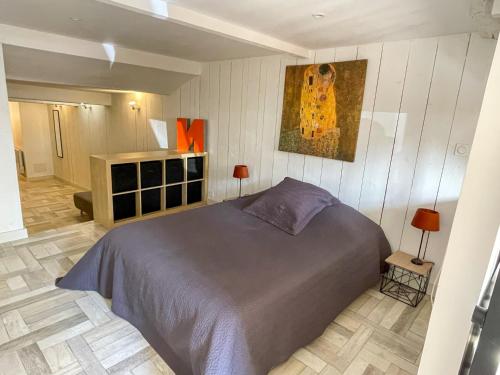 une chambre avec un lit et un tableau au mur dans l'établissement Maison cosy et atypique, à Arzens