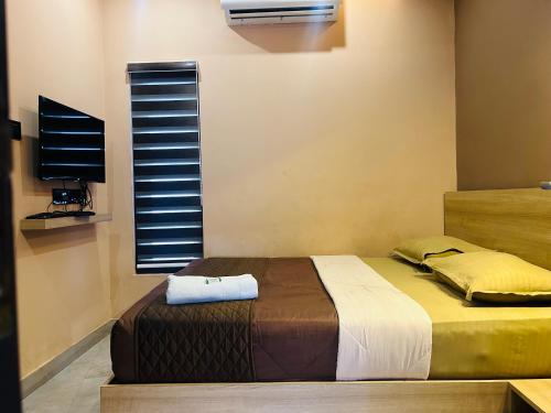 a bedroom with a bed with a television and a window at NIDRA INN in Kozhikode