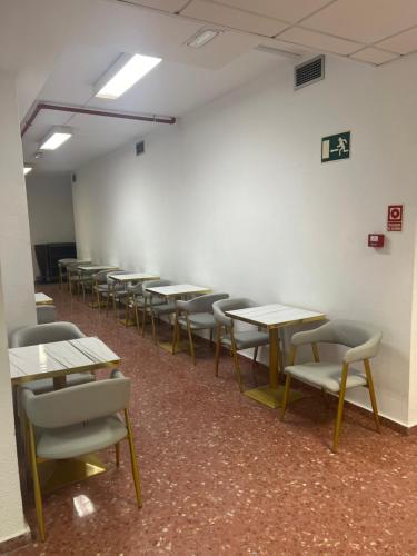 una habitación vacía con mesas y sillas. en just hostel capsules, en Alicante