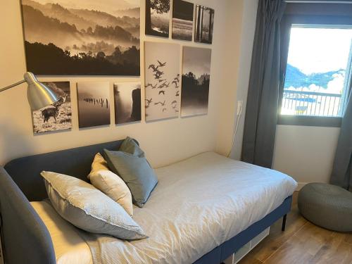 a room with a bed with pictures on the wall at Mirador de Telera - Precioso apartamento en el pueblo con espectaculares vistas in Panticosa