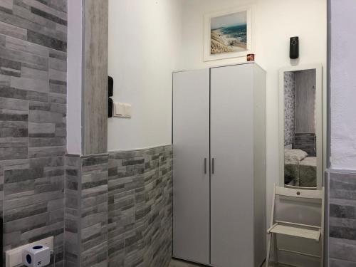 La salle de bains est pourvue d'un réfrigérateur blanc et d'un mur en carrelage. dans l'établissement Milan Soria Luxury House, à Benidorm