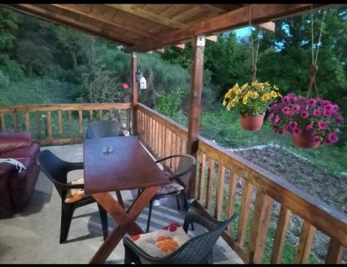 a wooden deck with a table and chairs on a porch at Planinska kuca in Rap