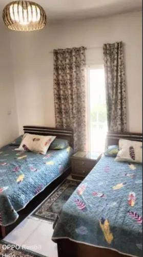 a bedroom with two beds and a window at الحي الاول 6 اكتوبر مجاورة 3 in 6th Of October