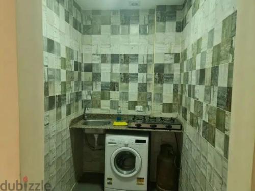 a laundry room with a washing machine and a sink at الحي الاول 6 اكتوبر مجاورة 3 in 6th Of October