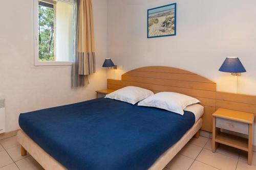 - une chambre avec un grand lit bleu et deux oreillers dans l'établissement maison piscine proche plage, à Ondres