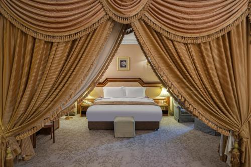 una camera da letto con un grande letto con tende di Al Shohada Hotel a La Mecca