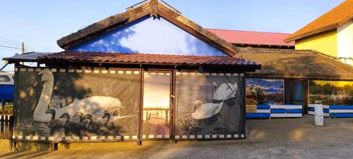 un mural de animales en el lateral de un edificio en Pensiunea La Sorin en Murighiol