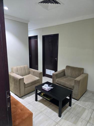a living room with two chairs and a coffee table at ماجيك سويت الرقعى Magic Suite AlRaggi in Kuwait