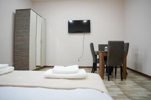 a room with two beds and a table with chairs at Square Inn in Gyumri
