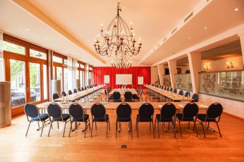 una gran sala de conferencias con una mesa grande y sillas en Le Saint Georges en Gruyères