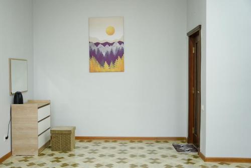 a room with a white wall with a picture on the wall at Square Inn in Gyumri