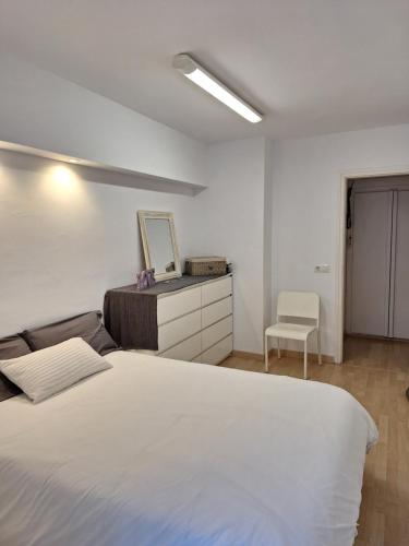 1 dormitorio con 1 cama blanca grande y 1 silla en CostaBrava Colera Apartament, en Colera