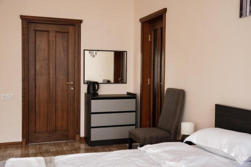 a bedroom with a bed and a chair and a mirror at Square Inn in Gyumri