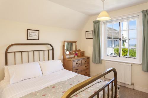 a bedroom with a bed and a window at Coachman's Cottage, West Porlock in Porlock