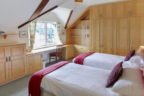 a bedroom with two beds and a window at Vale View Apartment in Porlock