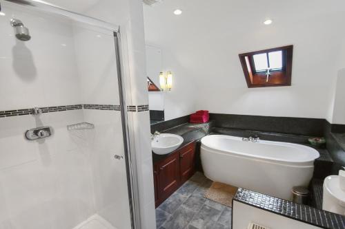 a bathroom with a tub and a sink and a shower at Vale View Apartment in Porlock