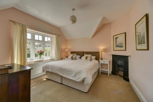 een slaapkamer met een groot bed en een open haard bij Coach House in Washford