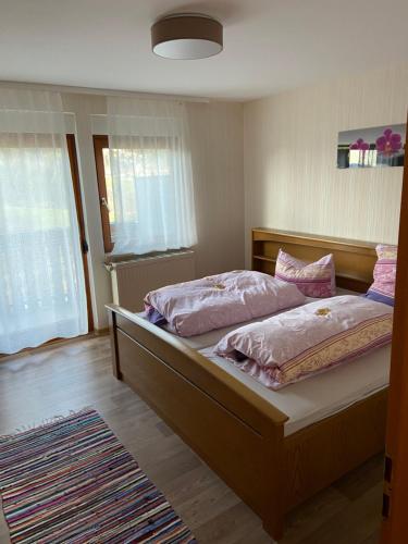 1 dormitorio con 1 cama grande con sábanas rosas en Ferienhof Brutoni, en Bad Peterstal-Griesbach