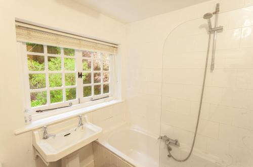 y baño con bañera, lavamanos y ducha. en Worthy Cottage en Porlock