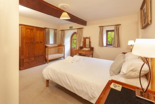 um quarto com uma cama branca e uma janela em Mill Cottage em Luxborough