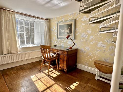 ein Heimbüro mit einem Schreibtisch und einem Stuhl in der Unterkunft Orchard Cottage in Charles