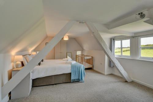 a attic bedroom with a bed and a window at Yenworthy Cottage in Culbone