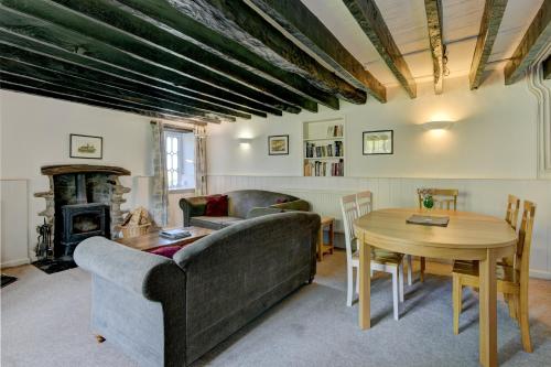 CulboneにあるYenworthy Cottageのリビングルーム(ソファ、テーブル、暖炉付)
