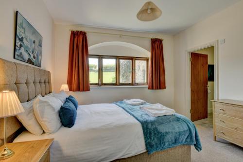 a bedroom with a large bed and a window at Yenworthy Barn in Culbone