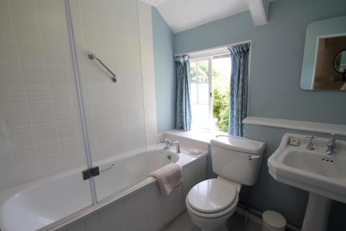 La salle de bains est pourvue de toilettes, d'une baignoire et d'un lavabo. dans l'établissement Ball Cottage, à Winsford