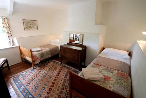 a small bedroom with two beds and a dresser at Ball Cottage in Winsford