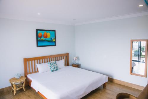 a bedroom with a white bed and a window at SEN VILLA Boutique in Bao Loc