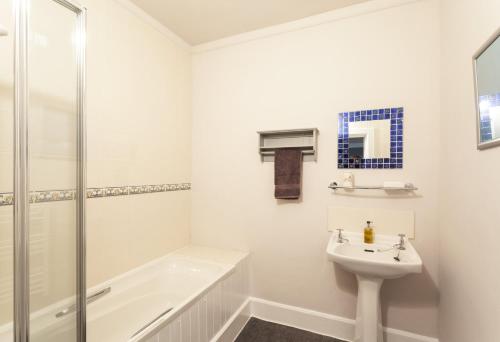 波洛克的住宿－Farm Cottage, West Luccombe，白色的浴室设有水槽和淋浴。