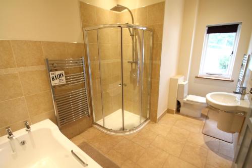 ein Bad mit einer Dusche und einem Waschbecken in der Unterkunft Redway Lodge in Porlock