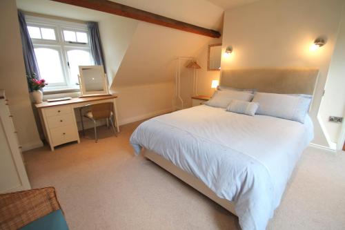 Schlafzimmer mit einem großen weißen Bett und einem Schreibtisch in der Unterkunft Redway Lodge in Porlock