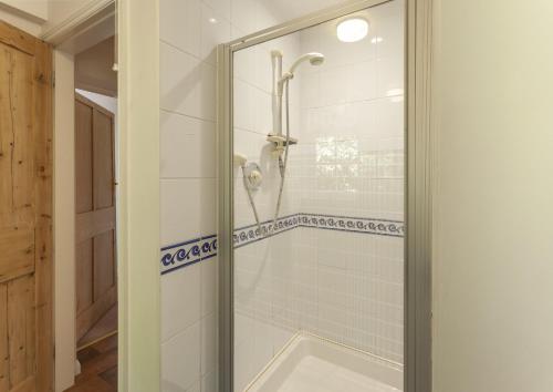 a shower with a glass door in a bathroom at Jacobs Pond, Near Monksilver in Stogumber