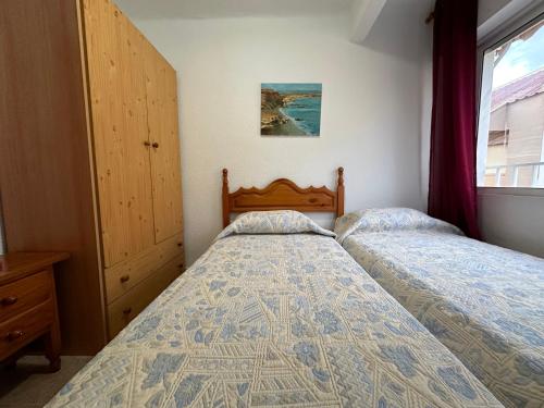 1 Schlafzimmer mit 2 Betten und einem Fenster in der Unterkunft 2 dormitorios 95 m de la playa in Los Alcázares