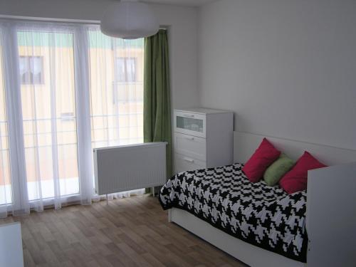 um quarto com uma cama com almofadas vermelhas e verdes em Apartment Třeboň em Třeboň