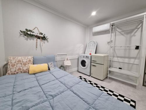 a bedroom with a large bed and a washing machine at Urban Stay Anyang in Anyang