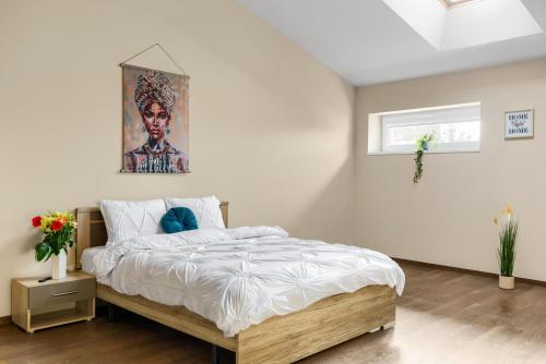 una camera da letto con un letto e un dipinto sul muro di ARI Central Grand SkyView - Family Apartment a Arad