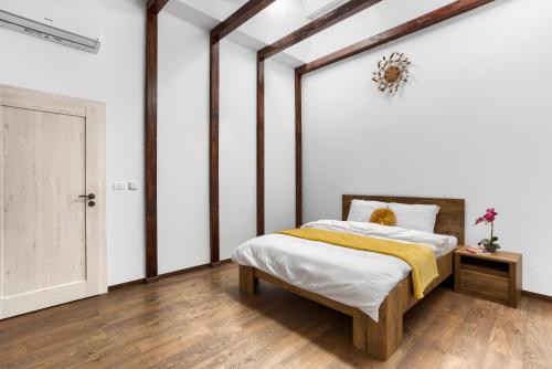 una camera da letto con un letto con una coperta gialla di ARI Central Grand SkyView - Family Apartment a Arad