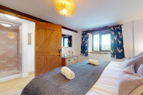 sypialnia z dużym łóżkiem z dwoma ręcznikami w obiekcie Jasper Cottage Hawkridge w mieście Dulverton