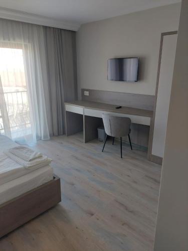 a bedroom with a desk with a bed and a chair at Pensiunea Normandia in Timişoara