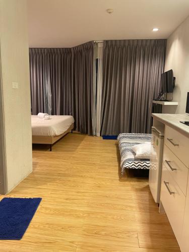 a room with a bedroom with a bed and a television at Grand Blue Condominium by Mary in Mae Pim