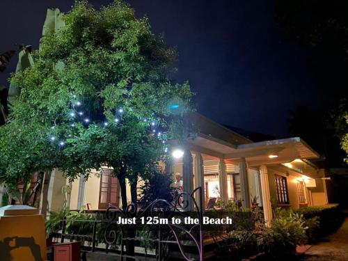 una casa con un árbol delante de ella por la noche en Sujatha Villa Paradise, en Tangalle
