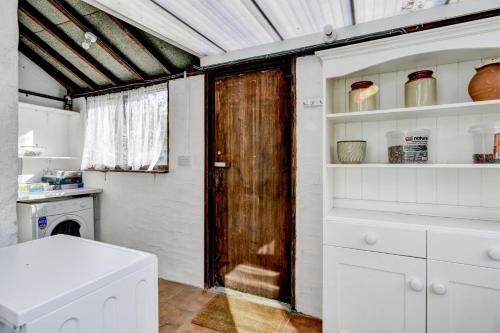 a bathroom with a wooden door in a kitchen at Riverside Cottage, Brendon in Countisbury