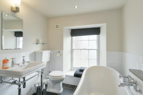 a bathroom with a tub and a toilet and a sink at 48 Swain Street, Watchet in Watchet